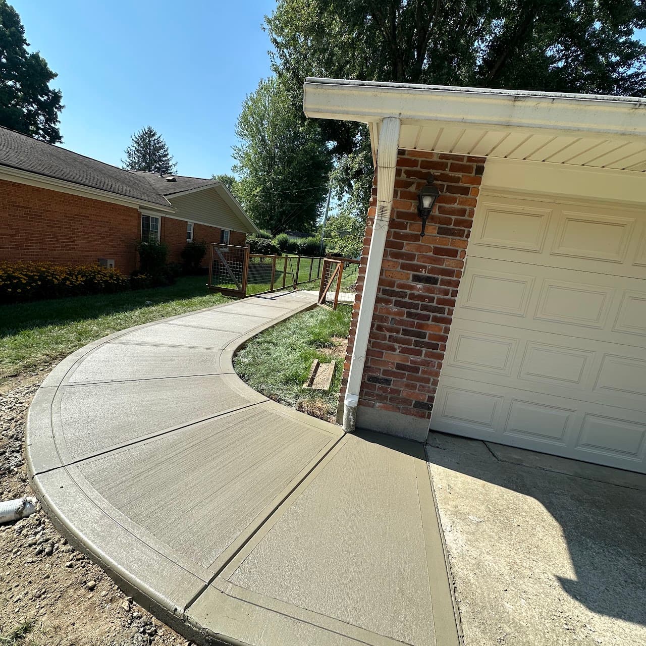 Curved concrete driveway approach to a two-car garage