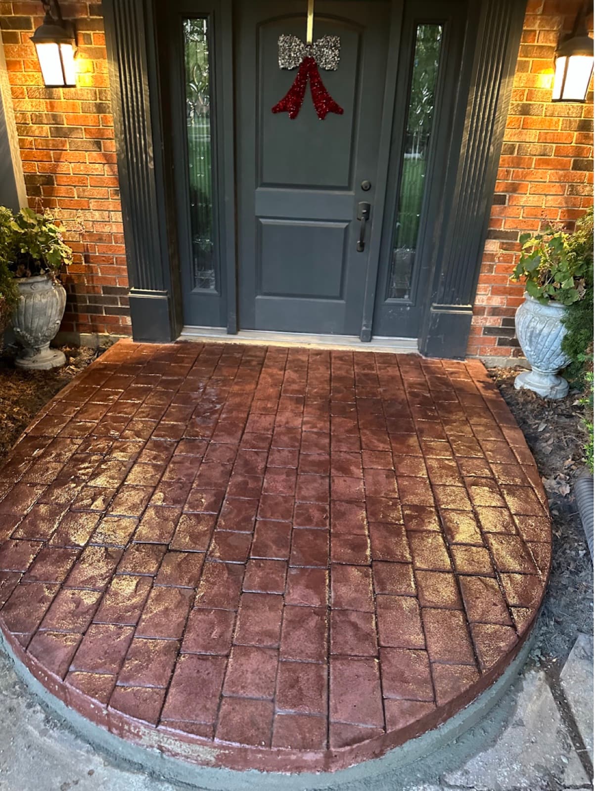 Stamped and colored brick-pattern concrete entry porch in red tones