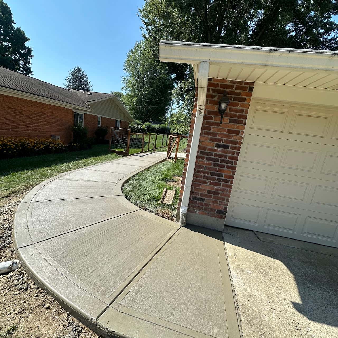 Curved concrete driveway approach to a two-car garage