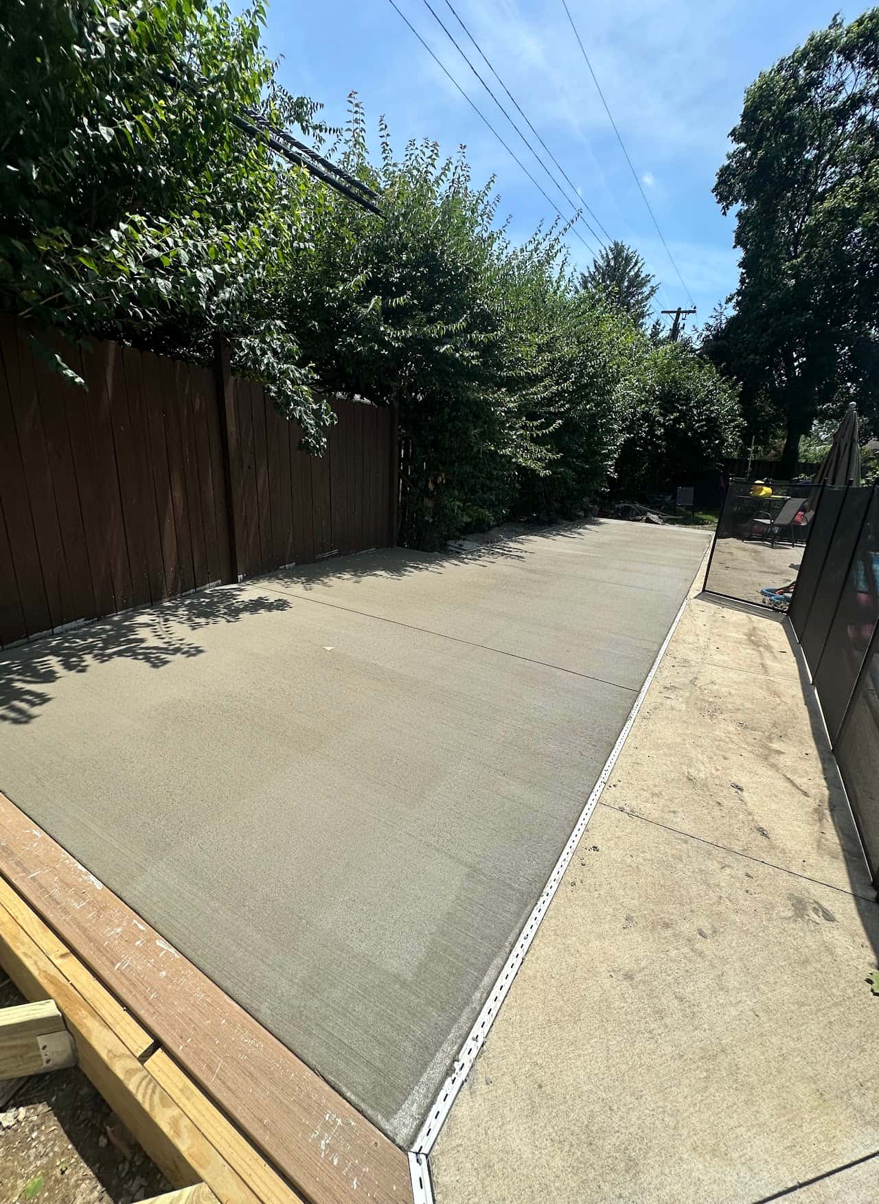 Long fenced concrete driveway with crisp broom finish