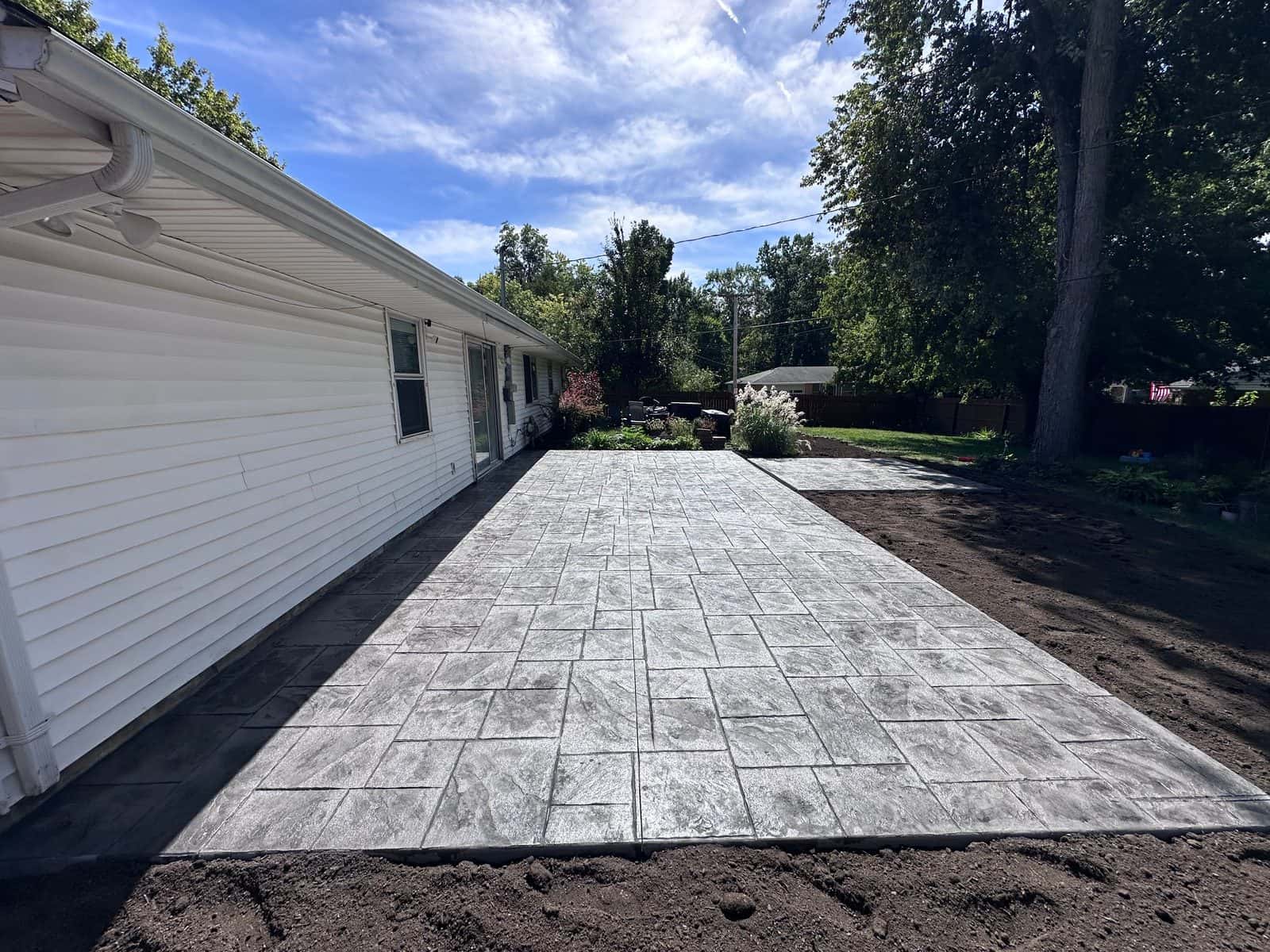 Stone-pattern stamped concrete patio running the length of a ranch home